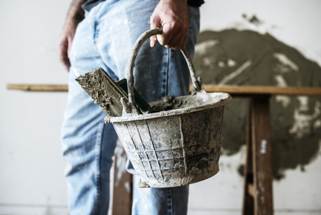Handyman holding basket cement for construction